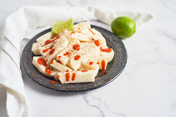 Traditional mexican jicama cutted with chili and piquant sauce. Mexican food.