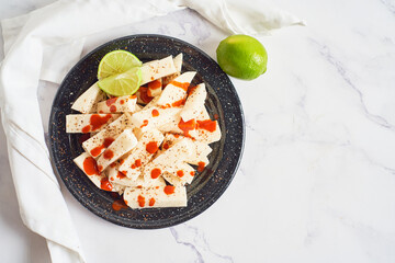 Mexican Traditional snack, jicama or yam bean, with chili, chamoy, sauce and lime