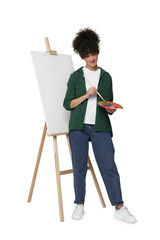 Young woman painting on easel with canvas against white background