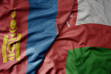 Fototapeta premium big waving realistic national colorful flag of mongolia and national flag of oman .
