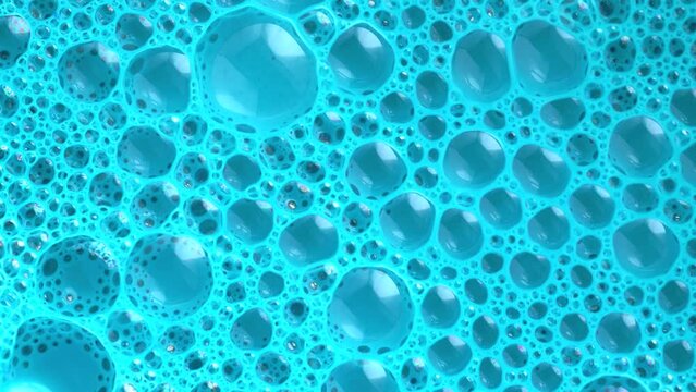 Magic wallpaper, soap sud macro structure. Blue foam soap with bubbles, rotates abstract background. Colorful soap foam with popping bubbles background. Abstract macro molecule pattern.