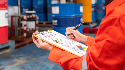 A worker is checking on the hazardous chemical material information form with background of...