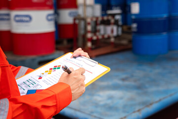 A worker is checking on the hazardous chemical material information form with background of...