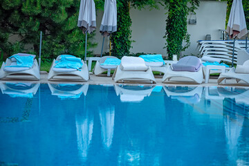 
cozy relaxation by the small pool. rows of sun loungers and the calm waters of the pool.