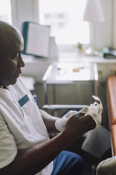 Male Healthcare Worker Wearing Gloves In Clinic