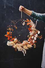 Crop woman with autumn floral wreath