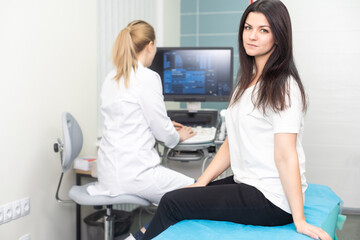 Doctor using ultrasound scanning machine for examining a thyroid of woman.
