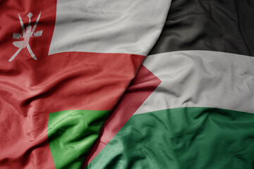 Obraz premium big waving realistic national colorful flag of oman and national flag of palestine .