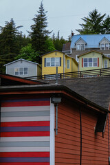 Street city view with wooden houses, shops, cars and mountain wilderness nature in Ketchikan, Alaska, popular cruise destination for whale watching in wildlife tours