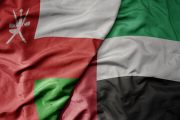 big waving realistic national colorful flag of oman and national flag of united arab emirates .