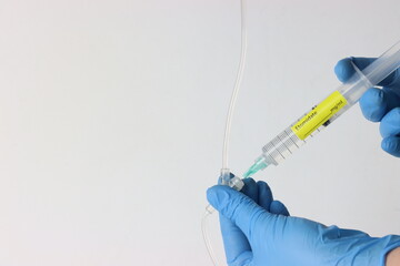 Professional wearing gloves injecting Etomidate into a intravenous set.