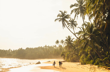 three people walking in a scenic coconut beach at sunset time.
Silent Beach, Tangalle, Sri Lanka