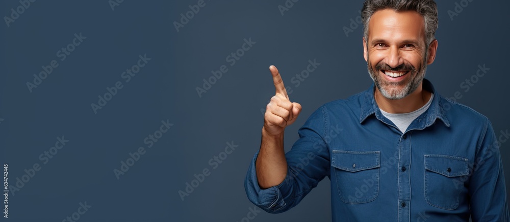Leinwandbilder Smiling middle aged man pointing happily with both hands showing object in empty area