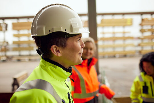 Side view of smiling engineer wearing hardhat at industry