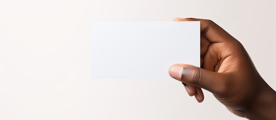 Obraz premium Biracial man s hand with blank business card on white background representing business and stationery