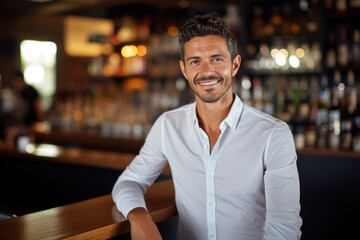 Happy young Latin businessman looking at a camera in the office, headshot portrait.