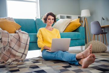 Photo of pretty successful recruiter girl sitting fluffy carpet use wireless netbook coworking...