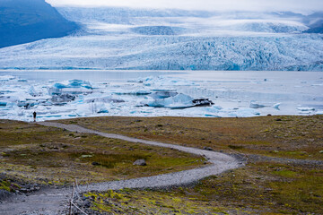 A small pathway leads to the majestic glacier in Iceland.