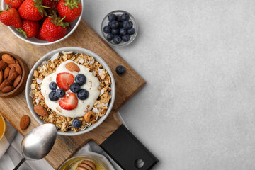 Fototapeta na wymiar Tasty granola, yogurt and fresh berries served on light table, flat lay with space for text. Healthy breakfast