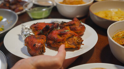 Close-up halal food Indian fried chicken dish. Happy Asia muslim wife cooking Ramadan dinner together bring food plate in dining room, Family catering celebration Eid al-Fitr togetherness at home.