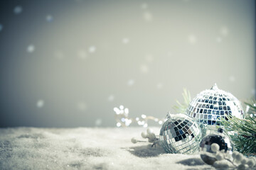 Fototapeta na wymiar Silver Christmas balls amd snowflakes on shiny background. Christmas greeting card with copy space.