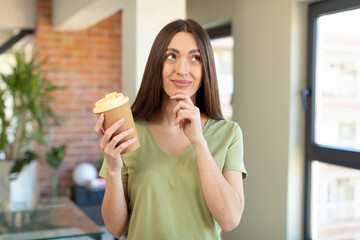 smiling with a happy, confident expression with hand on chin. take away coffee concept