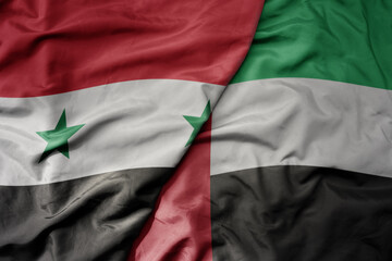 big waving realistic national colorful flag of syria and national flag of united arab emirates .