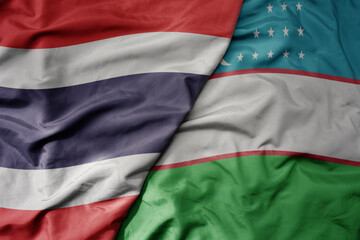 big waving realistic national colorful flag of thailand and national flag of uzbekistan .