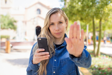 looking serious showing open palm making stop gesture. smartphone concept