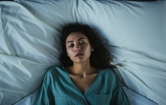 Young sleepless woman on her bed. Concept image on mental health issues. Generative AI.