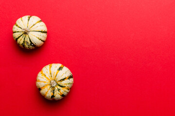 Autumn composition of little orange pumpkins on colored table background. Fall, Halloween and Thanksgiving concept. Autumn flat lay photography. Top view vith copy space