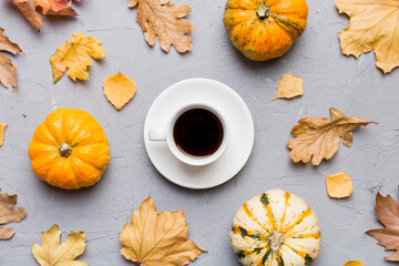 Flat lay composition with colorful Autumn cup of coffee and leaves on a color background. top view
