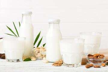 Set or collection of various vegan milk almond, cashew, on table background. Vegan plant based milk and ingredients, top view
