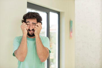 young crazy bearded man looking desperate and frustrated, stressed, unhappy and annoyed, shouting and screaming