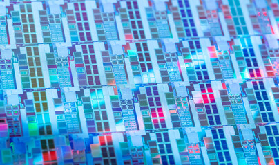 silicon wafer with microchips reflecting different colors.