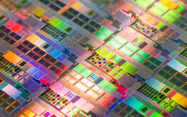 silicon wafer with microchips reflecting different colors.