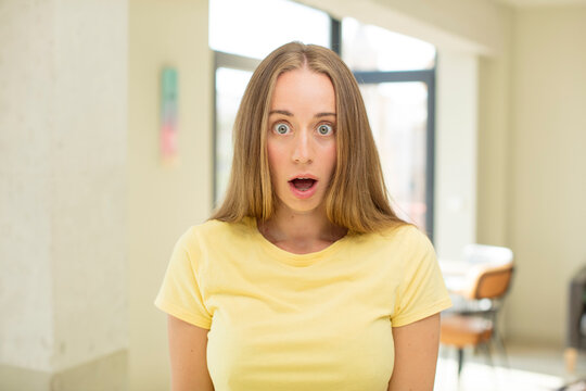 pretty blond woman looking very shocked or surprised, staring with open mouth saying wow