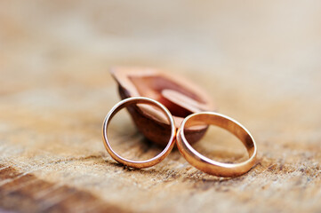 Fototapeta na wymiar Couple of gold wedding rings on wooden background