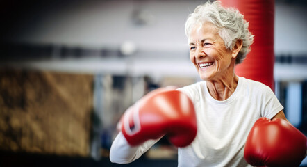 Senior woman exhibiting strength and resilience as a boxer, breaking stereotypes with confidence and vitality in her focused exercise routine.