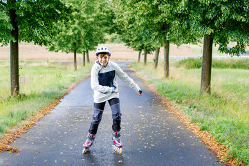 Active school boy skating in summer park, healthy lifestyle for children. Happy teenager with...