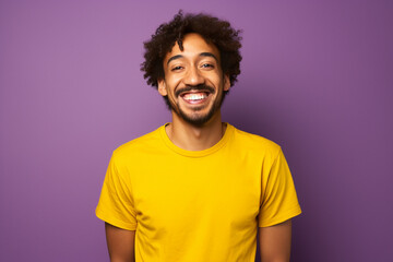 Fototapeta na wymiar a man dressed in yellow t shirt is smiling against a background