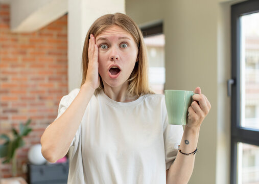 young pretty woman feeling extremely shocked and surprised. coffee cup concept