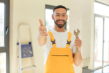 arab handsome man arab man smiling happily and offering or showing a concept. handyman with a wrench