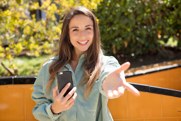 pretty woman smiling happily and offering or showing a concept. smartphone concept