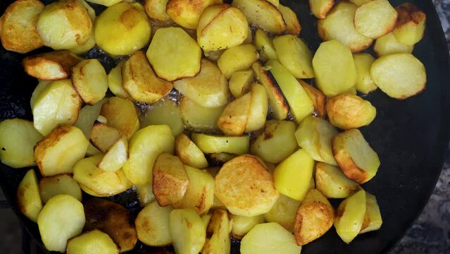 frying potatoes in a skillet , Close-Up Of Fried Potatoes In A Frying Pan.