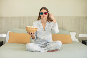 Obraz premium young pretty woman looking surprised, realizing a new thought, idea or concept. popcorns and movie concept