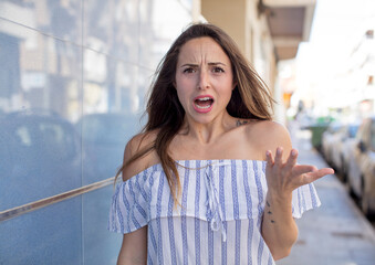 pretty woman looking angry, annoyed and frustrated screaming wtf or what’s wrong with you