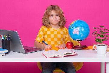 School child studying in classroom at elementary school. Kid studying on lesson on pink red isolated background.