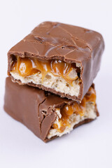 Chocolate bar with caramel fillings. Sweet chocolate bar broken into two pieces.