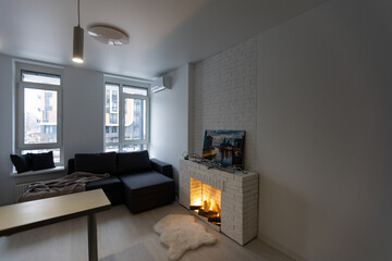 Modern studio flat with small kitchen, sofa.